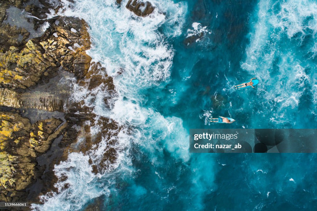 Vista aérea dos surfistas em suas pranchas de surf.