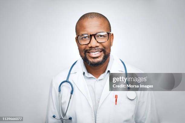 doctor wearing eyeglasses on white background - visage homme africain photos et images de collection