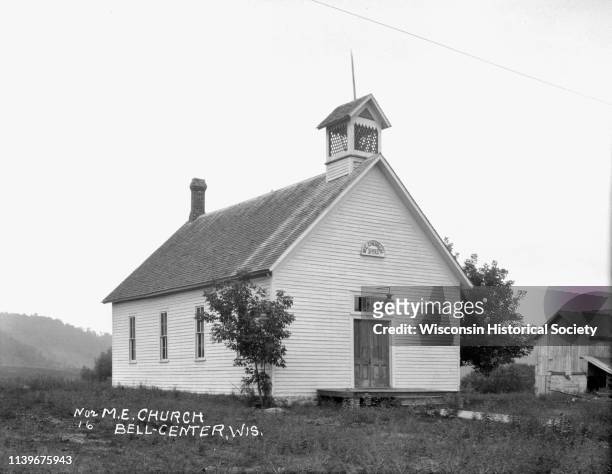 Exterior view of the Methodist Evangelical Church, Bell Center, Wisconsin, 1916. The building features a sign that says: ME 1893. There is a lamp...