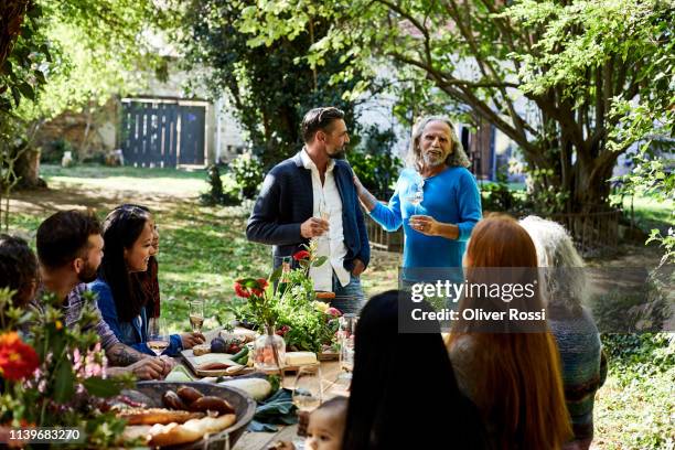 senior man with friend making a speech on a garden party - young woman and senior lady in a park stock pictures, royalty-free photos & images