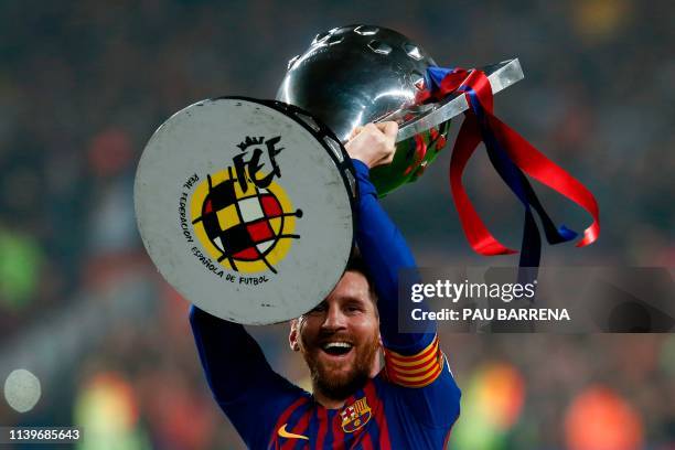 Barcelona's Argentinian forward Lionel Messi celebrates with the Liga trophy as Barcelona won their 26th league title after the Spanish League...