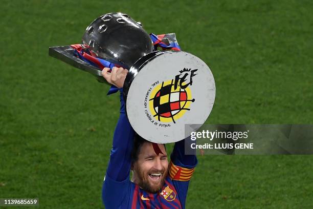 Barcelona's Argentinian forward Lionel Messi raises La Liga trophy as he celebrates becoming La Liga champions after winning the Spanish League...