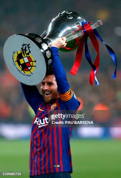 Barcelona's Argentinian forward Lionel Messi celebrates with the Liga trophy as Barcelona won their 26th league title after the Spanish League...