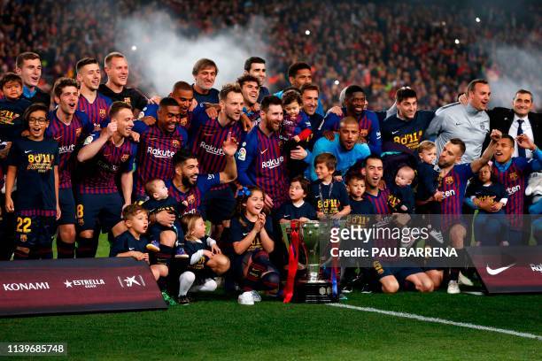 Barcelona's players celebrate with the Liga trophy after winning the club's 26th league title at the end of the Spanish League football match between...