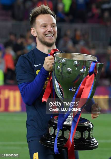 Barcelona's Croatian midfielder Ivan Rakitic holds the trophy as he celebrates becoming La Liga champions after winning the Spanish League football...