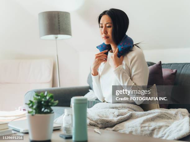 jonge aziatische vrouw ziek thuis - electric blanket stockfoto's en -beelden