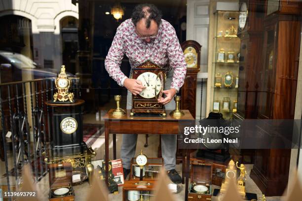 Duncan Clements of Pendulum of Mayfair antique clock specialists carries out the summertime adjustment of the clocks, regulators and timepieces in...