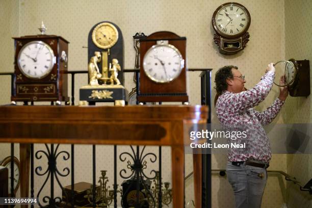 Duncan Clements of Pendulum of Mayfair antique clock specialists carries out the summertime adjustment of the clocks, regulators and timepieces in...