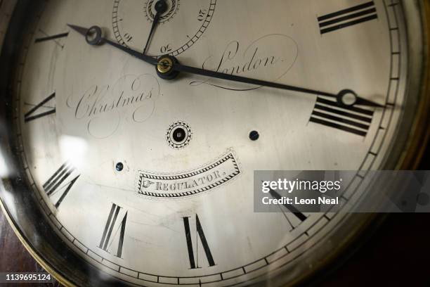 The face of a Christmas London regulator is seen as Duncan Clements of Pendulum of Mayfair antique clock specialists carries out the summertime...