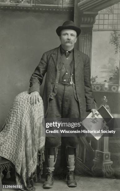 Studio portrait of William Tennant in front of a painted backdrop, Black River Falls, Wisconsin, 1897. He was a newspaper and magazine agent in Black...