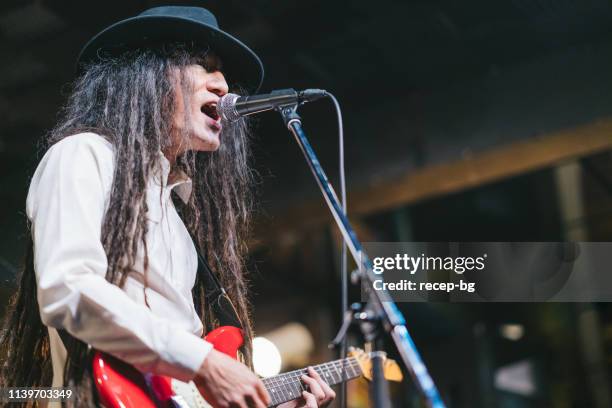 male musician with dreadlocks playing guitar and singing on stage - japanese culture on show at hyper japan stock pictures, royalty-free photos & images