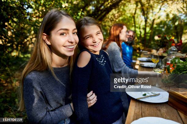 portrait of two happy sisters on a garden party - sister stock photos et images de collection