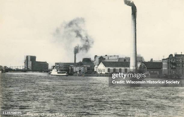 View from Fox River of chimneys, buildings, and boat, Green Bay, Wisconsin, 1906.