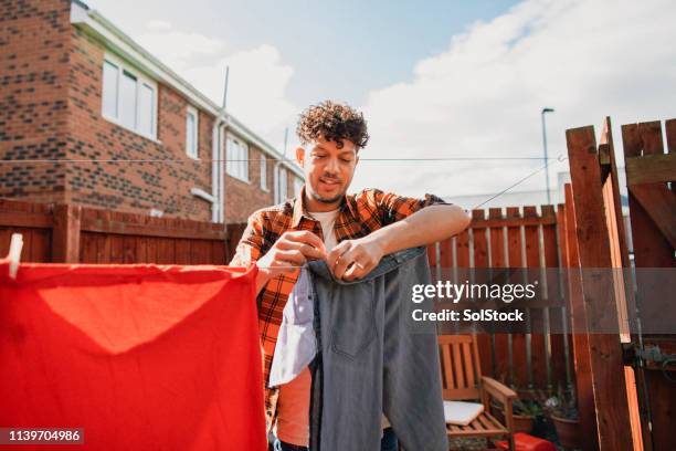 man doing household chores - clothesline imagens e fotografias de stock