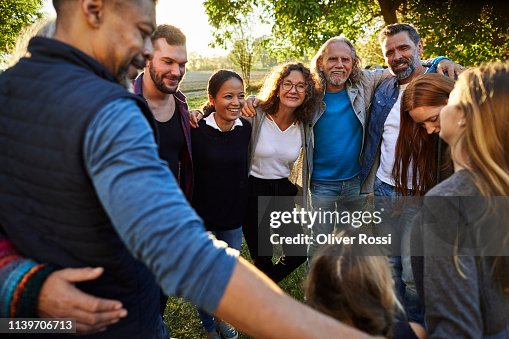 Group of happy people embracing on a garden party at sunset Group of happy people embracing on a garden party at sunset