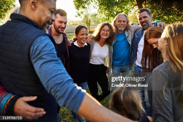 group of happy people embracing on a garden party at sunset - local ストックフォトと画像