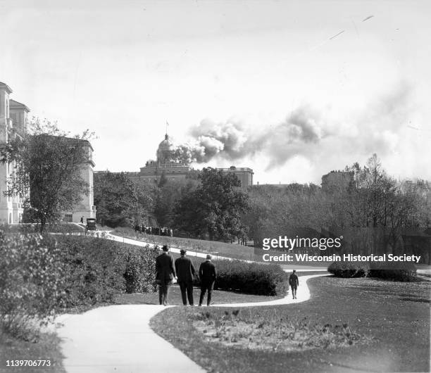 People walking along the Linden Drive path watch as Bascom Hall dome burns on the University of Wisconsin-Madison campus, Madison, Wisconsin, October...