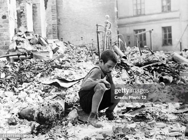 At the beginning of World War two, a Polish boy sits grieving in the ruins of a street in Warsaw, Poland, September 1939.
