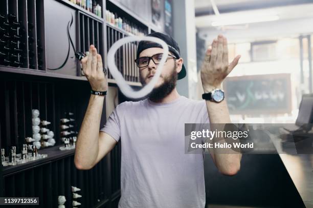 man shaping a smoke ring by moving hands - electronic cigarette smoke ストックフォトと画像