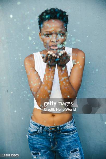 vertical shot of beautiful woman blowing glitter - camisa sin mangas fotografías e imágenes de stock