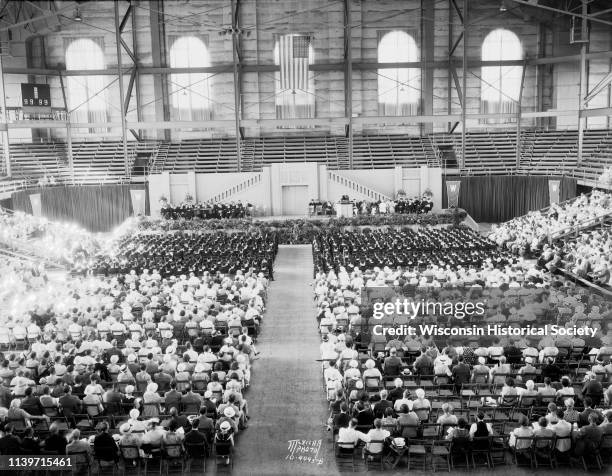 Speakers, graduates, and guests are seated in the University of Wisconsin-Madison Field House, the venue for the University of Wisconsin-Madison...