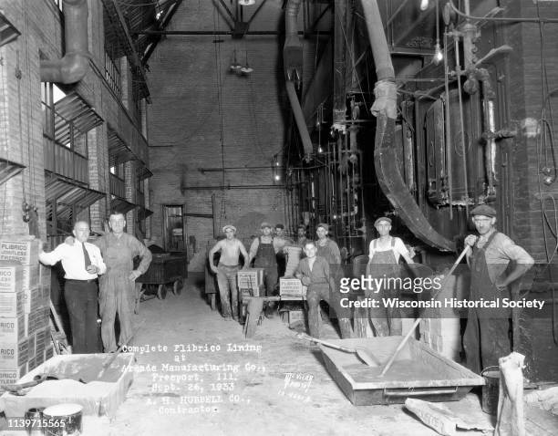 Nine brick layers with supervisor in engine room, Freeport, Illinois, September 26, 1933. Caption on print reads 'Complete Plibrico Jointless...