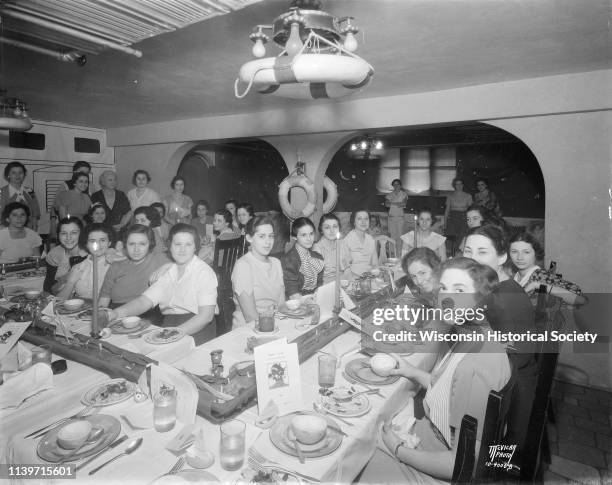 Alpha Epsilon Phi sorority women, seated at tables decorated with a marine theme, for an informal senior group finishing dinner at 135 Langdon...