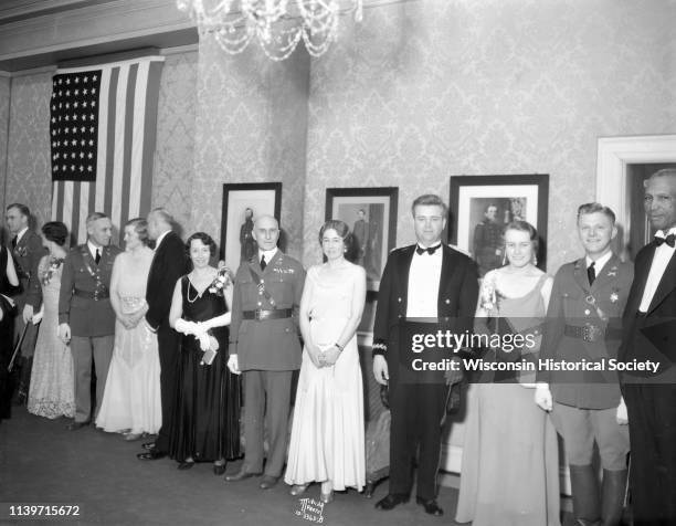 Attendees in formal wear stand in a military ball receiving line, from right to left, Sam Pierce, Arnold H Dammen, Helga Gundersen, Ralph M Immell,...