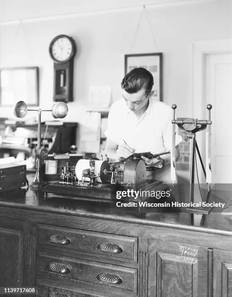 Albert Lorenz, assistant US meteorologist, is reading a wind velocity instrument in the laboratory at North Hall at the University of...