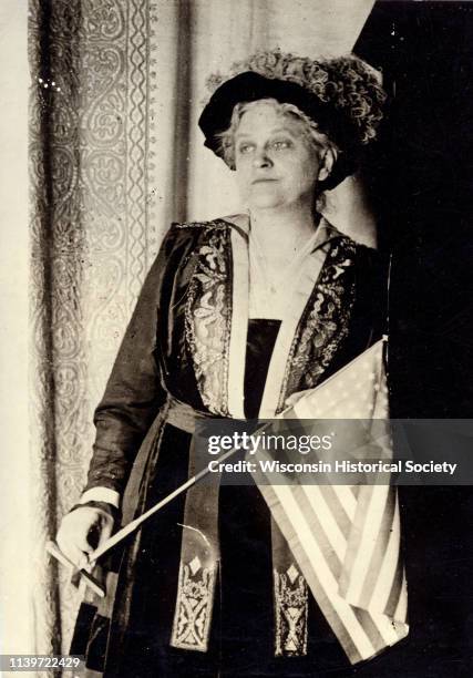 Carrie Chapman Catt, suffragist and peace advocate, holding an American flag, 1917.