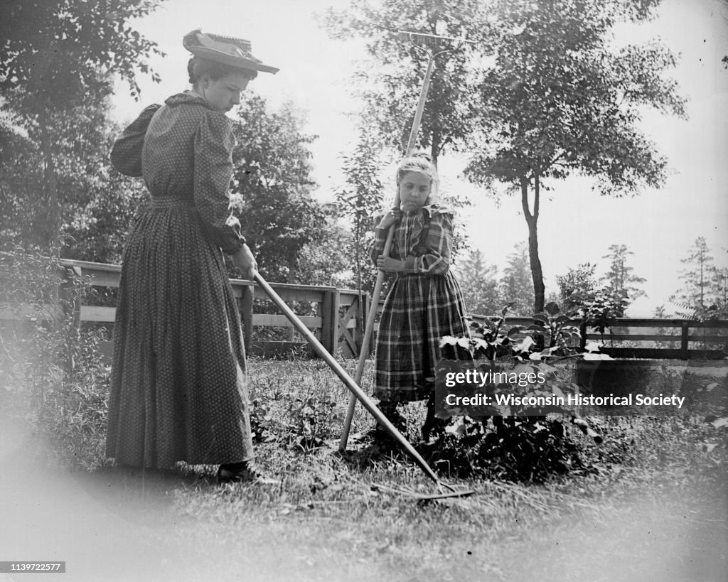 Woman Racking Lawn Woman in hat and young girl raking the lawn, Black River Falls,... News ...