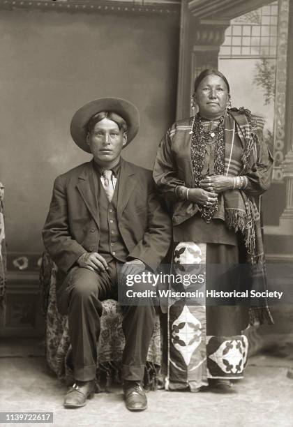 Studio portrait of George Monegar and Fannie Stacy Lincoln Monegar posing standing in front of a painted backdrop, Black River Falls, Wisconsin,...