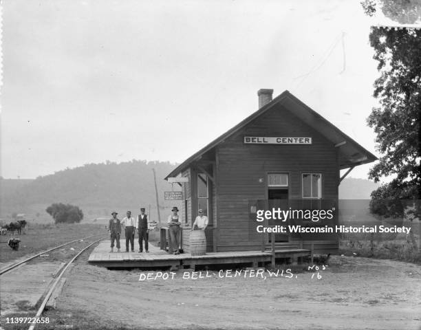 Exterior view of the Bell Center depot with five men posing on the platform, Bell Center, Wisconsin, 1916.