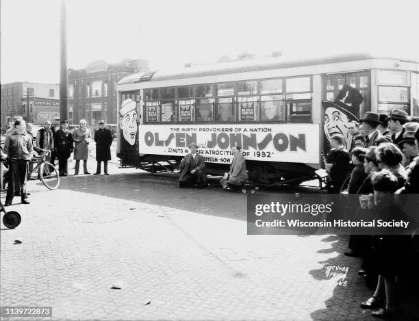 Comedians Ole Olsen and 'Chic' Johnson, called 'the mirth provokers of a nation,' posing in front of a streetcar that displays an advertisement for...