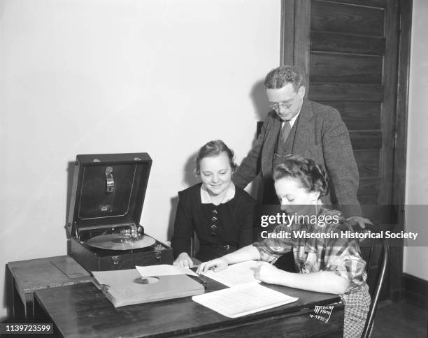 University of Wisconsin Professor Miles L Hanley watches coeds Laura Severson and Theressa Fein, while they work on transcriptions for a linguistic...