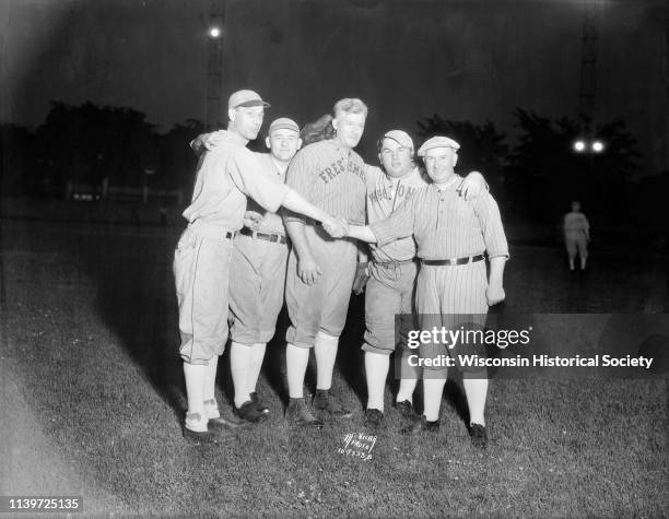 Five legislators dressed in baseball uniforms shake hands before a baseball game at Breese Stevens Field, Madison, Wisconsin, June 25, 1935. L to R:...