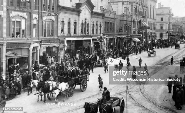 University of Wisconsin-sponsored parade rolls down Mifflin Street on the Capitol Square, Madison, Wisconsin, 1909. One of the banners appears to be...