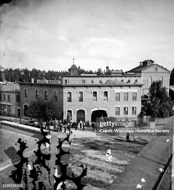 Employees with a wagon loaded with barrels of beer in front of Hausmann's Capital Brewery at the corner of State and Gorham Streets, Madison,...
