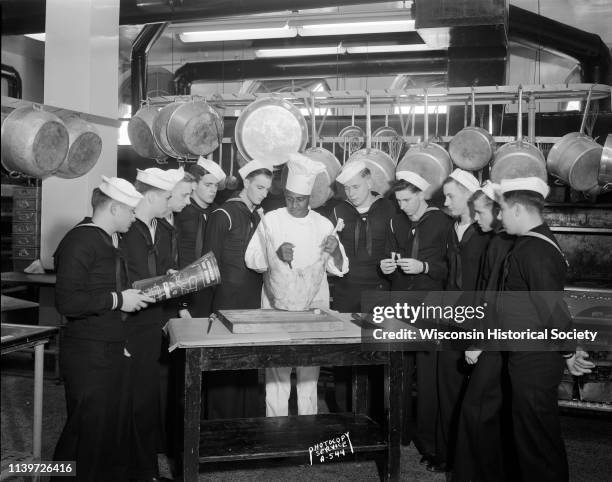 Ten Navy cooks and bakers watching meat carving demonstration by Chef Carson Gulley, UW residence hall chef, Madison, Wisconsin, September 9, 1943....