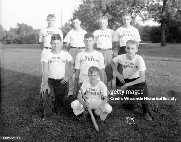 Group portrait of members of the Orpheum Theatre softball team, Madison, Wisconsin, August 27, 1934. They are wearing t-shirts that read 'Cool...