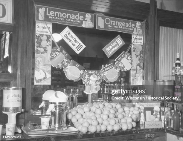 Ligget's Drug Store at 29 S Pinckney Street, with a lemonade display on the soda fountain, Madison, Wisconsin, August 14, 1934. The signs on the...