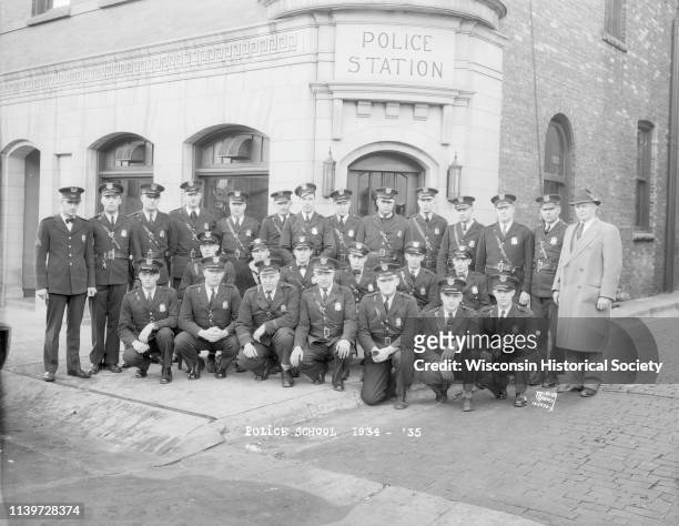 Group portrait of police officers taken in front of the Madison Police Station at 14-16 South Webster Street, Madison, Wisconsin, November 14, 1934....
