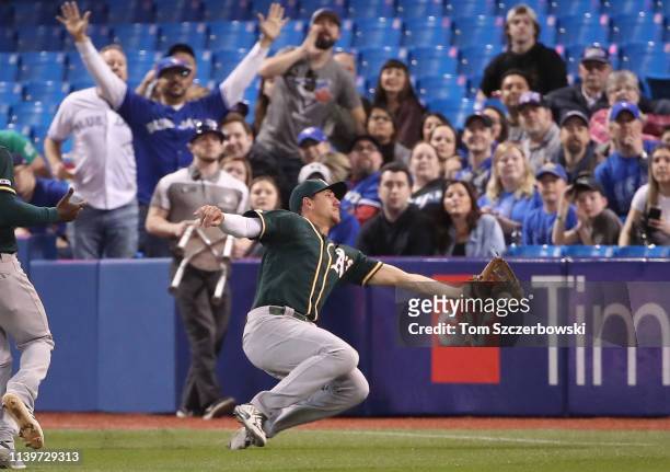 Stephen Piscotty of the Oakland Athletics makes a sliding catch in the fifth inning during MLB game action against the Toronto Blue Jays at Rogers...