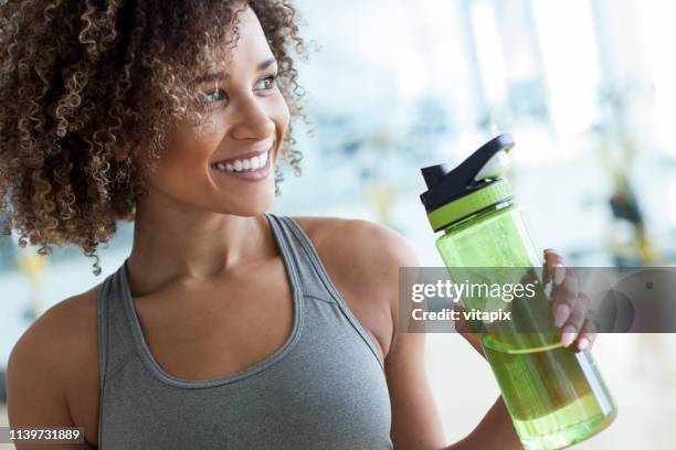 wassertrinken im gym - woman drinking water from bottle stock-fotos und bilder