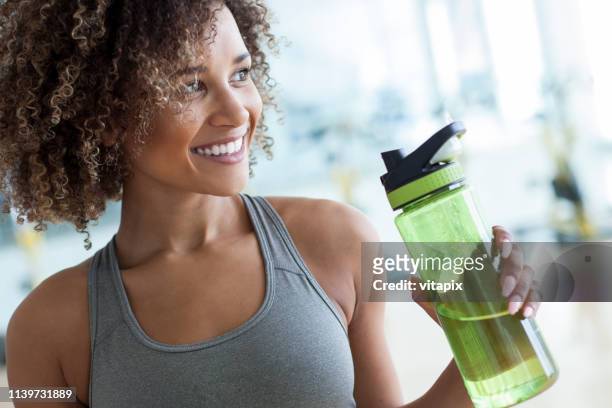 tomar un trago de agua en el gimnasio - skinny black woman fotografías e imágenes de stock