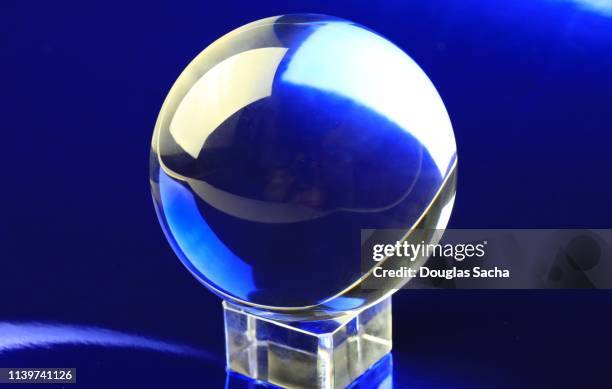 crystal ball on a blue background - crystal ball stock-fotos und bilder