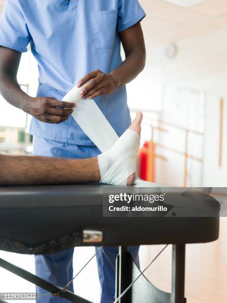 male's foot being wrapped with bandage - foot ligaments stock pictures, royalty-free photos & images