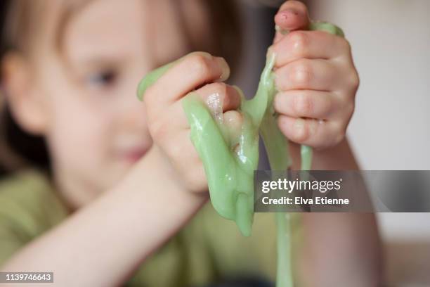 child squeezing novelty green slime through fingers - slimy stock pictures, royalty-free photos & images