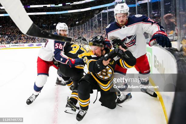 Brad Marchand of the Boston Bruins and Pierre-Luc Dubois of the Columbus Blue Jackets battle for the puck in Game Two of the Eastern Conference...