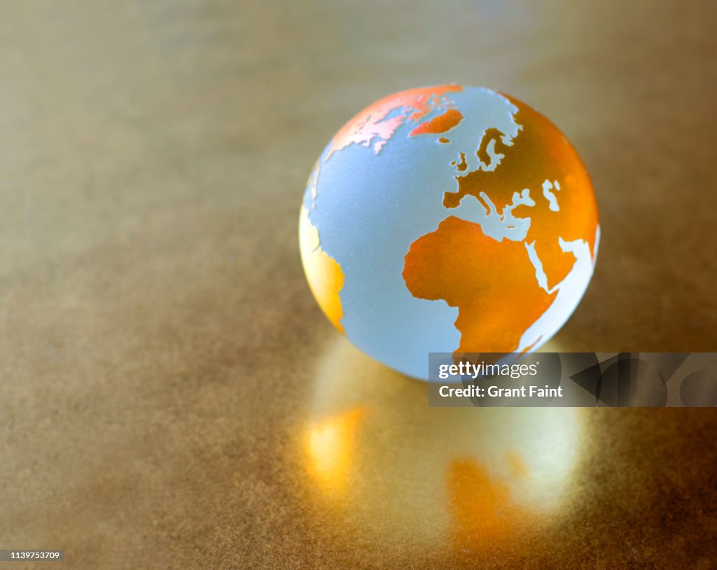 View of globe on gold background.